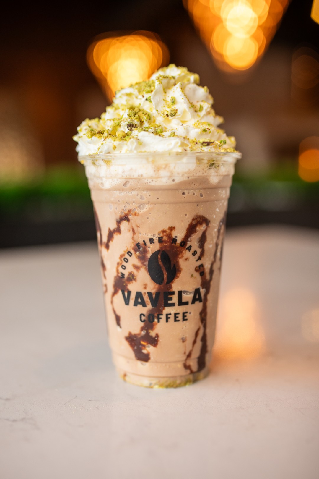 Iced coffee drink topped with whipped cream and pistachio at Vavela